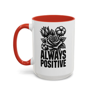 White mug with red handle and rim, featuring a black line drawing of a rose and text that reads "ALWAYS POSITIVE".