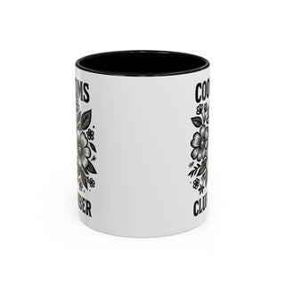 White mug with black interior, floral design, and "COOLS" text.