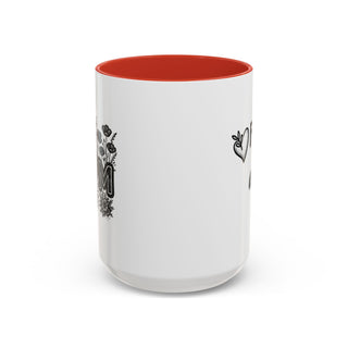 White mug with orange interior and black floral "Mom" graphic.