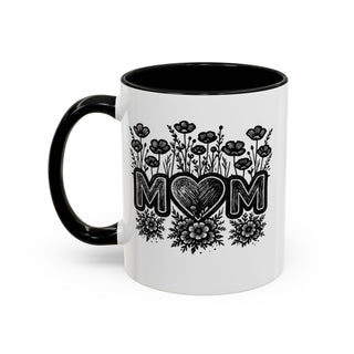 White mug with black rim and handle, featuring "MOM" in floral art.