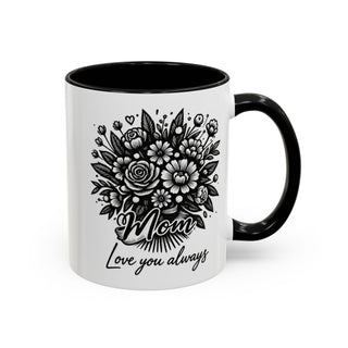 White mug with black rim and handle, featuring a floral bouquet and "Mom love you always".