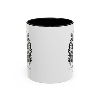 White mug with black floral designs and black interior.