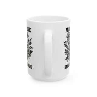 White mug with floral design and "Mama Always Blooms" text.
