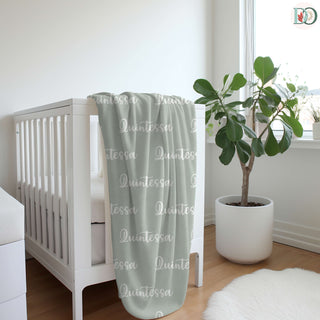 personalized name blankets in soft green, dusty lilac, deep rose, blush, and charcoal grey—each featuring a custom name in unique fonts for a cozy, heartfelt keepsake.