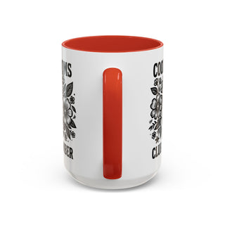 White mug with red interior, featuring floral designs and text.