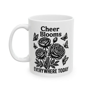 White mug with black floral design and text "Cheer Blooms Everywhere Today."