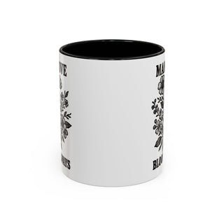 White mug with black floral design and text "MAKE LOVE ALWAYS BLOOM".