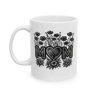 White mug with "MOM" in floral lettering and a heart design.