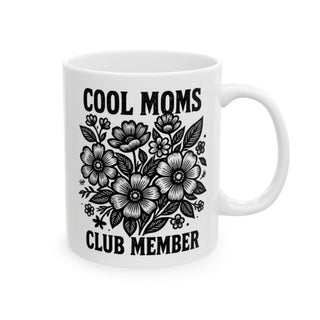 White mug with "Cool Moms Club Member" text and floral illustration.