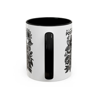 White mug with black interior and handle, featuring floral designs and "ALWA POSITI" text.