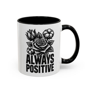 White mug with black rim and handle, featuring a rose and floral illustration with "ALWAYS POSITIVE" text.