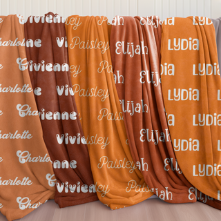 Personalized name blankets in cozy pumpkin, sienna, and sunset-inspired shades — each one a soft embrace from our Golden Hug Collection, designed to comfort, cheer, and celebrate with your chosen name and font.