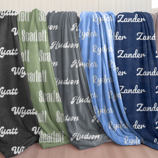 personalized name blankets in tones of navy, sky blue, graphite grey, sage green, and black — soft and comforting with gentle fonts in Doveora's Starshade Nest collection.
