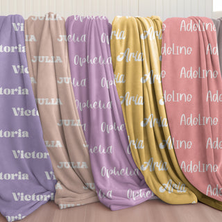 pastel-toned personalized name blankets in lavender, dusty rose, beige, golden yellow, and coral — part of Doveora’s Sunpetal Nest collection, offering gentle name customization with soft hues.