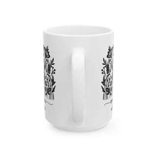 White mug with black floral design and text.