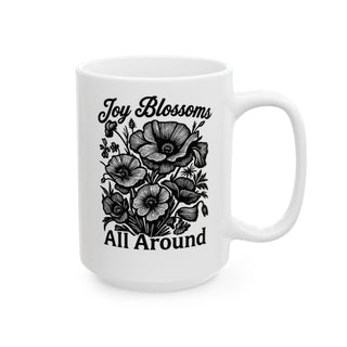 White mug with black floral design and "Joy Blossoms All Around" text.