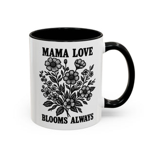 White mug with black handle featuring a floral illustration and "MAMA LOVE BLOOMS ALWAYS" text.