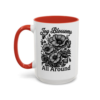 White mug with red interior and handle, featuring a floral design and text.