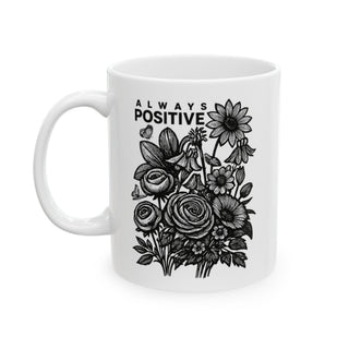 White mug with "ALWAYS POSITIVE" and floral line art design.