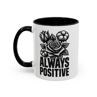 White mug with black handle and interior, featuring floral design and "ALWAYS POSITIVE" text.
